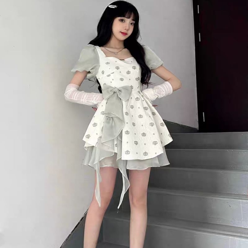 Váy xòe xốp trắng phối hoa nơ tua rua xanh