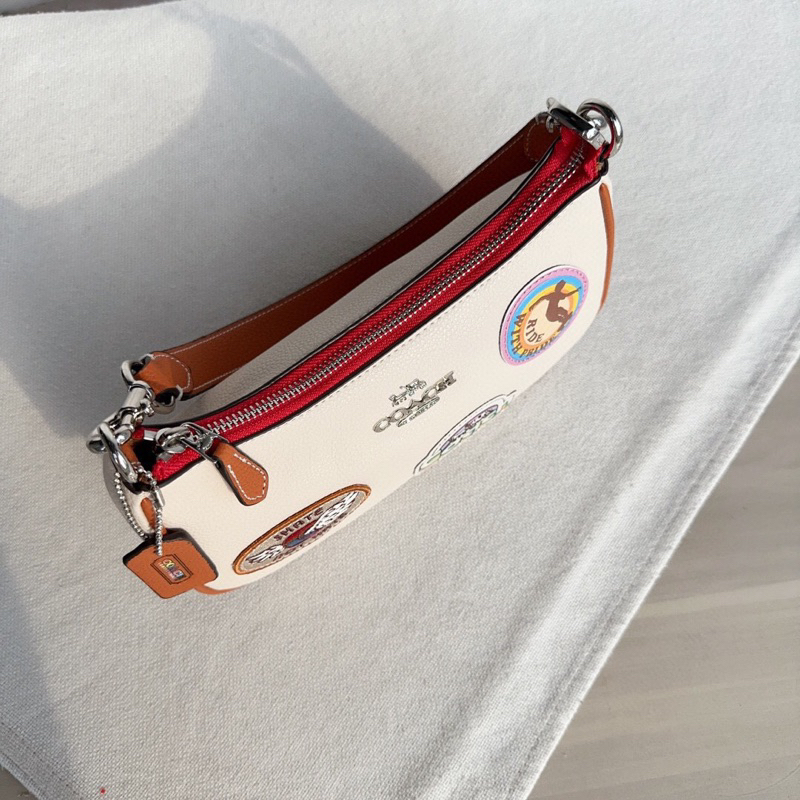 Túi kẹp nách dáng thuyền Coach Teri hoạ tiết sticker mới