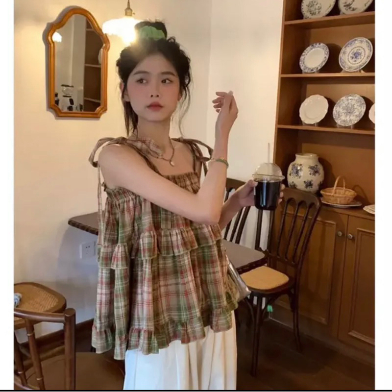 Áo caro kẻ đỏ bèo tầng babydoll thắt nơ vai xinh xắn.