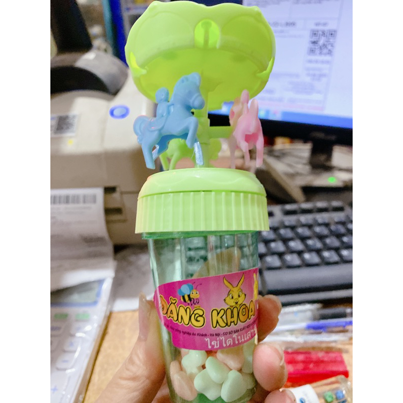 Vỉ 12 lọ kẹo xê kèm đồ chơi xích đu có đèn phát sáng