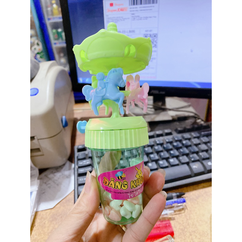 Vỉ 12 lọ kẹo xê kèm đồ chơi xích đu có đèn phát sáng