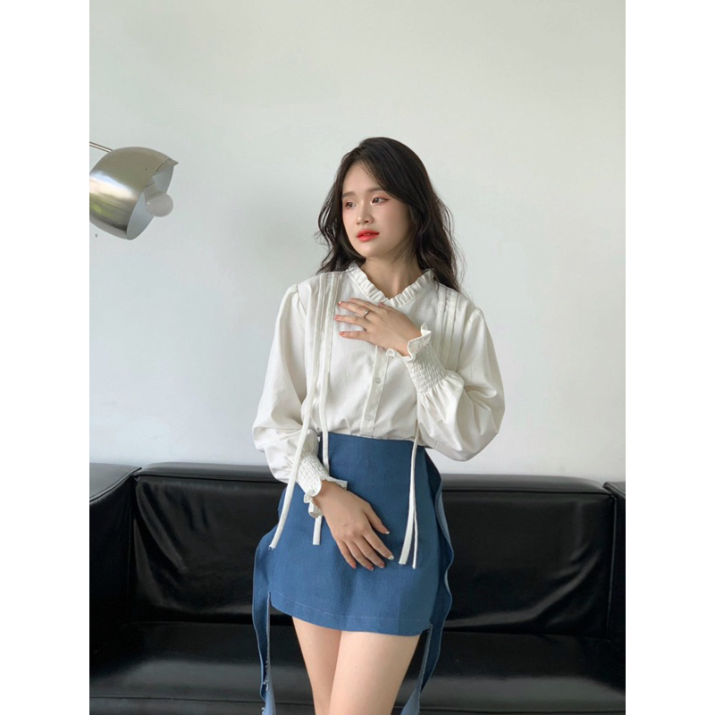 Áo sơ mi cổ bèo tay phồng nhún.