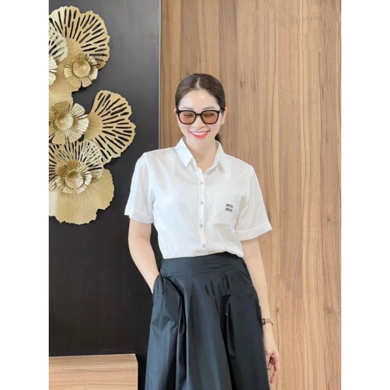 Áo sơ mi trắng gập gấu thêu chữ ngắn tay.