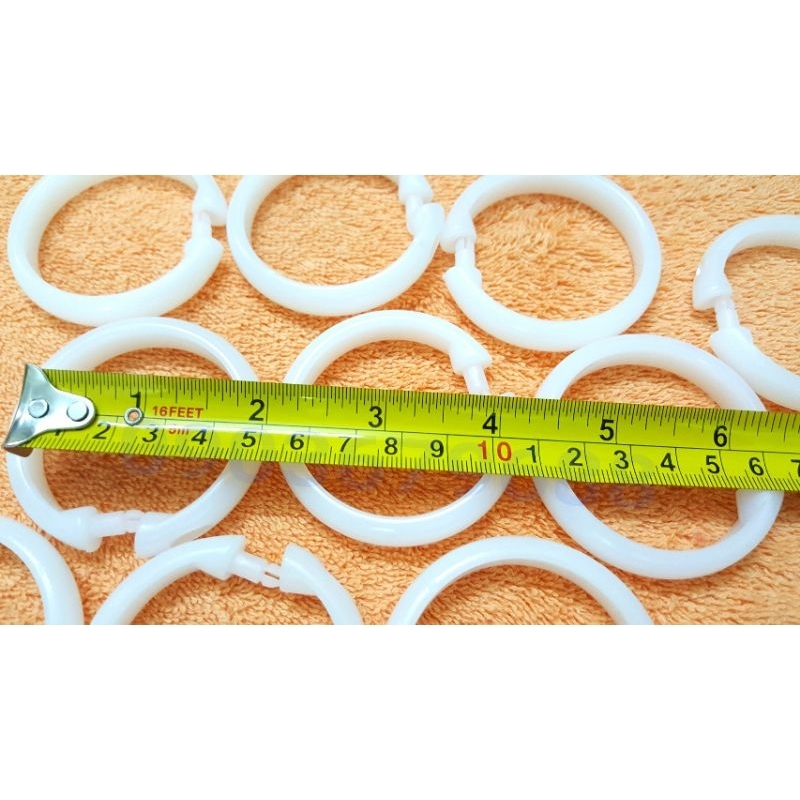 Bịch 10 cái khoen nhựa móc treo màn rèm màu nâu và trắng này có đường kính 5cm.