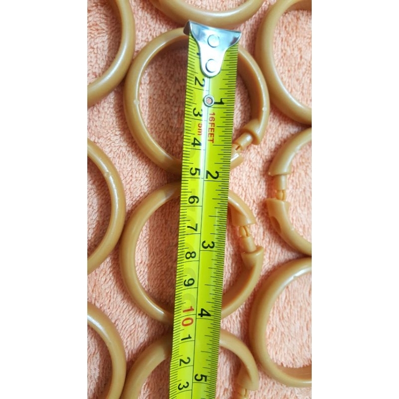 Bịch 10 cái khoen nhựa móc treo màn rèm màu nâu và trắng này có đường kính 5cm.