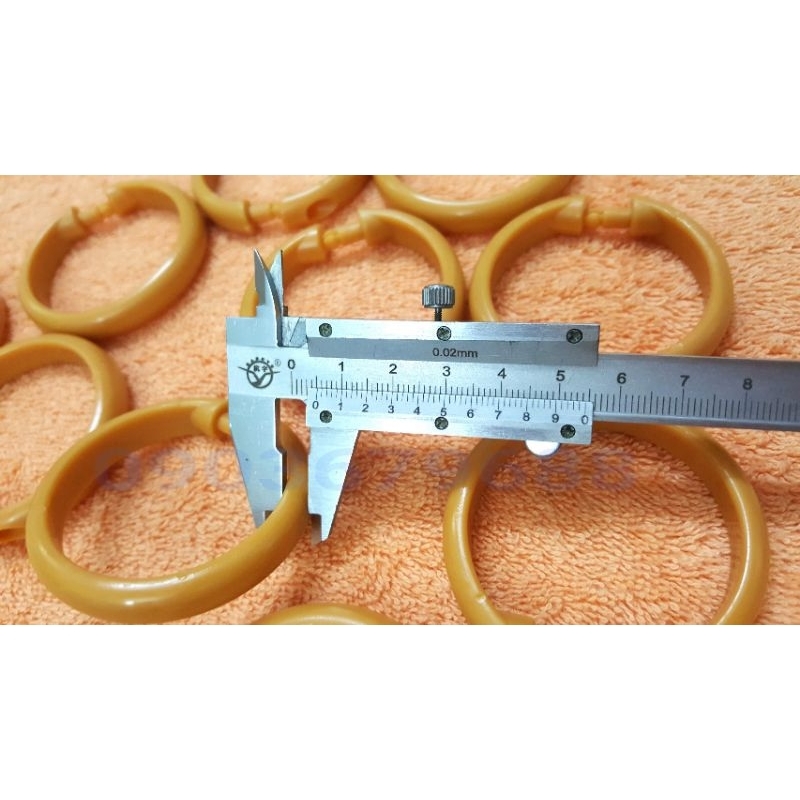 Bịch 10 cái khoen nhựa móc treo màn rèm màu nâu và trắng này có đường kính 5cm.