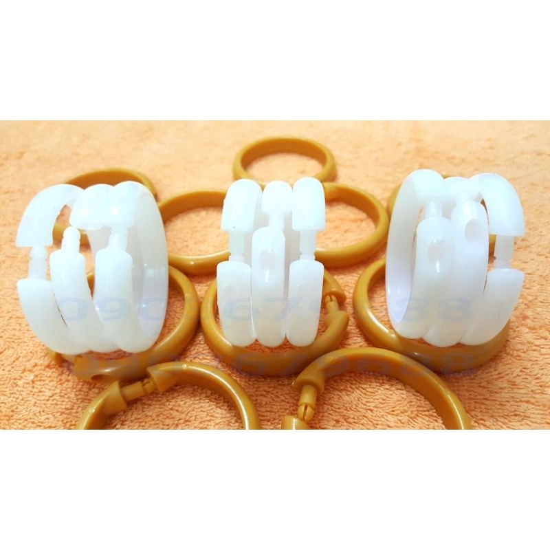 Bịch 10 cái khoen nhựa móc treo màn rèm màu nâu và trắng này có đường kính 5cm.
