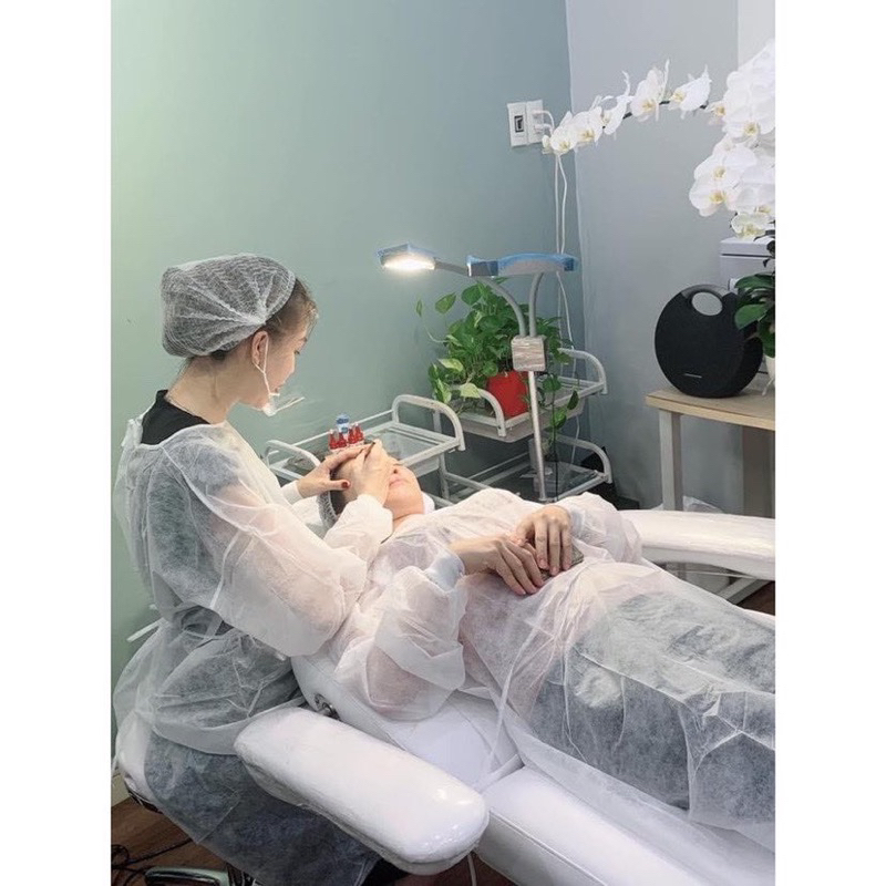 Áo bảo hộ và mũ sâu giúp cố định tóc trong phun xăm