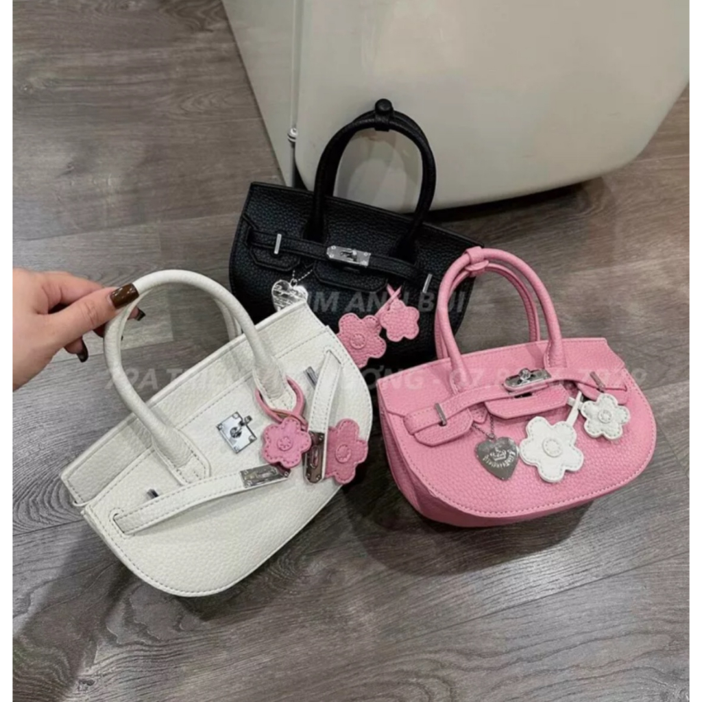 Túi xách nữ HM dáng bầu tag bạc kèm móc treo hoa.