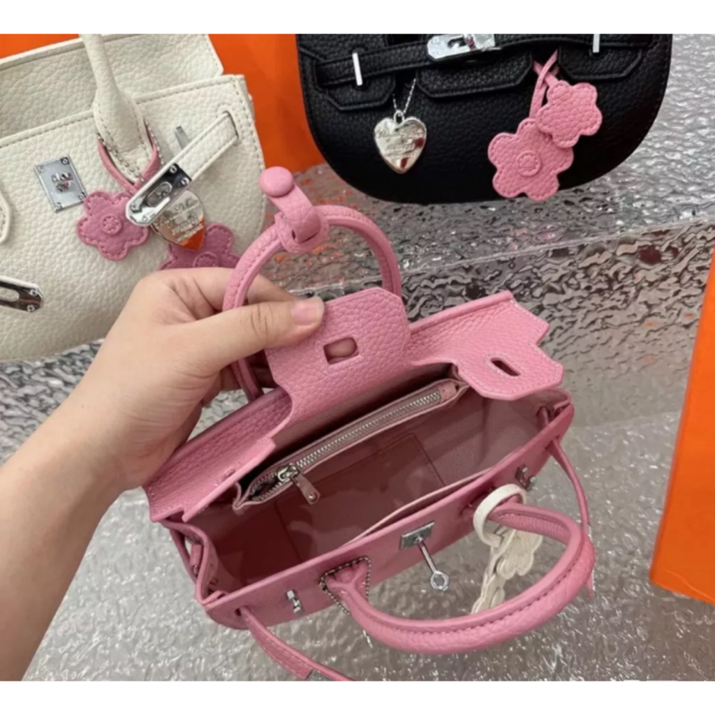 Túi xách nữ HM dáng bầu tag bạc kèm móc treo hoa.