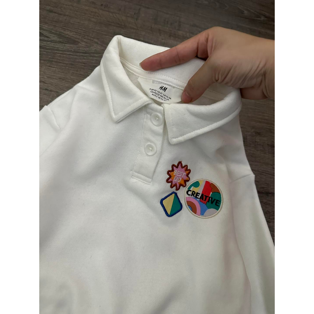 Áo nỉ polo trắng gắn stick bé gái