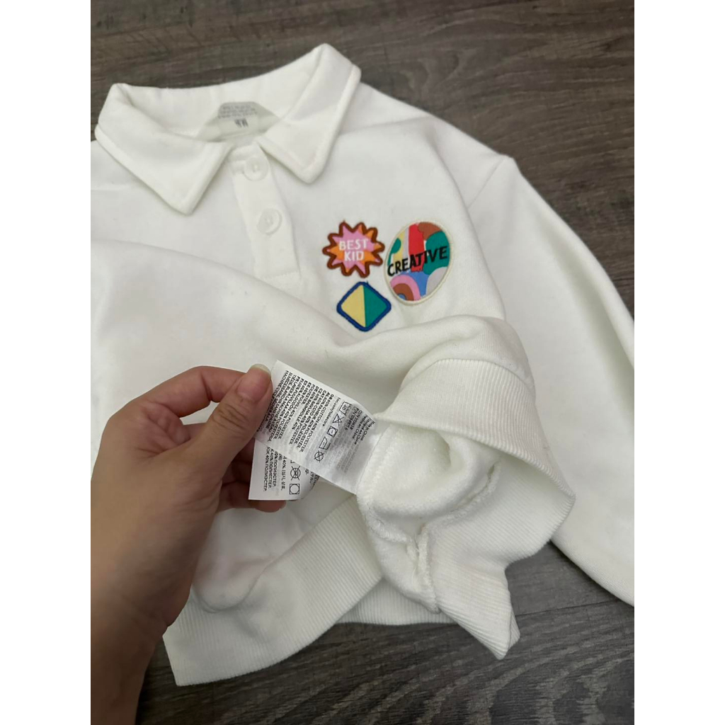 Áo nỉ polo trắng gắn stick bé gái