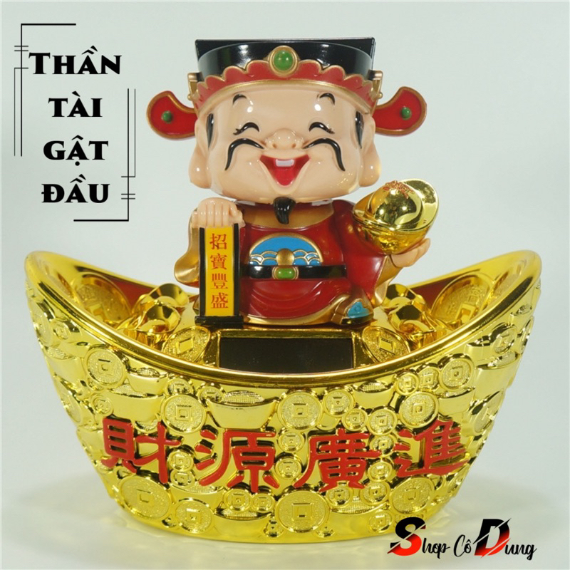 Tượng thần tài áo đỏ đứng trên ngân lượng phong thủy, gật đầu bằng năng lượng mặt trời