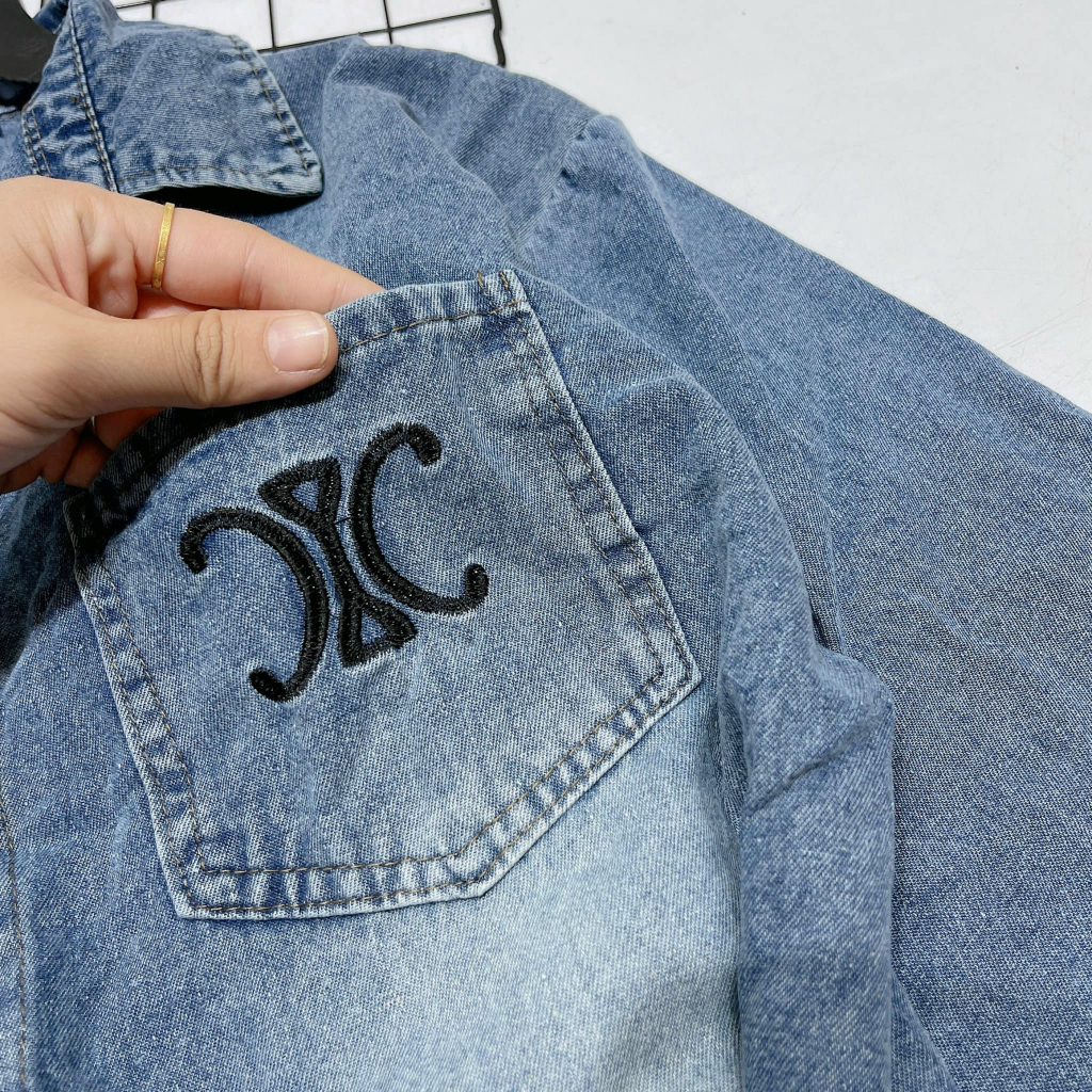 Áo sơ mi jeans thêu X túi vạt tôm đính cúc