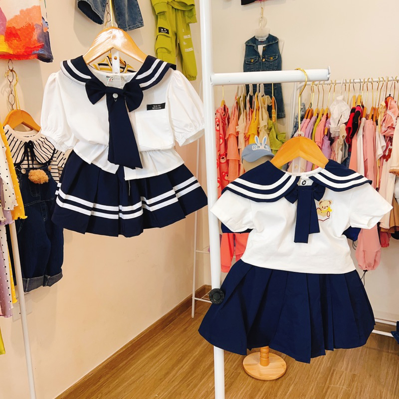 Set áo sơ mi cổ đính nơ và chân váy xếp ly đi học cho bé