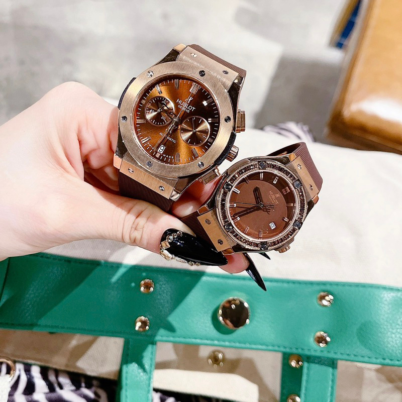 Đồng hồ cặp hublo.t nam, nữ dây cao su màu nâu máy pin
