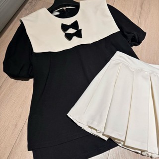 Áo sơ mi tay ngắn phồng nhẹ phối vạt trắng kèm 2 nơ đen nhỏ, áo nữ babydoll đính nơ kèm chân váy kiểu dáng Hot Trend | BigBuy360 - bigbuy360.vn