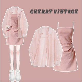 Set váy hai dây trơn màu hồng, váy ôm body thắt eo và áo sơ mi dài tay voan mỏng khoác ngoài đi biển