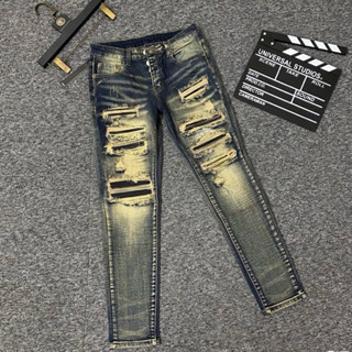 Quần jean bò nam Amiri wash rách loang tua vàng vá da đen đính 4 cúc khắc chữ hãng cao cấp