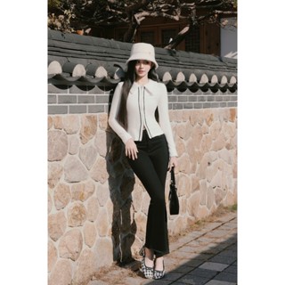 Áo cotton trắng dáng ôm, cổ tay phối vải lông & Quần bò đen dáng loe, túi trước đính tag Flane