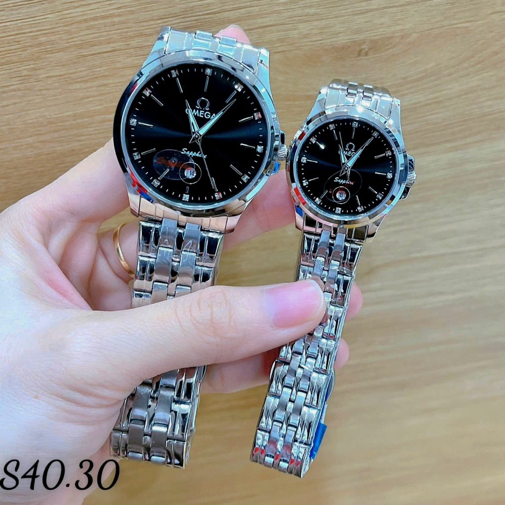 Đồng hồ cặp đôi OM 2 lịch máy pin chuẩn Nhật. Kính sapphire. Chống nước tốt. Màu mặt đen, vỏ bạc