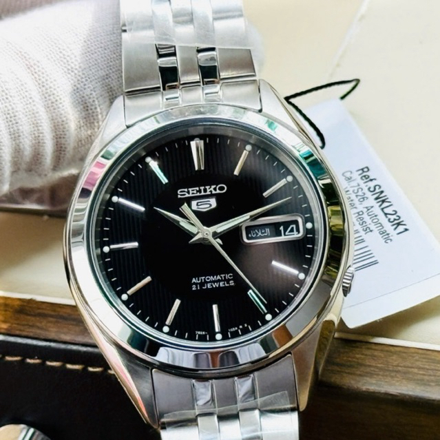 Seiko SNKL23K1 Automatic Nam Dây Thép Đen – Máy 7S26 – Kính Hardlex – Lịch Thứ Ngày – 39mm