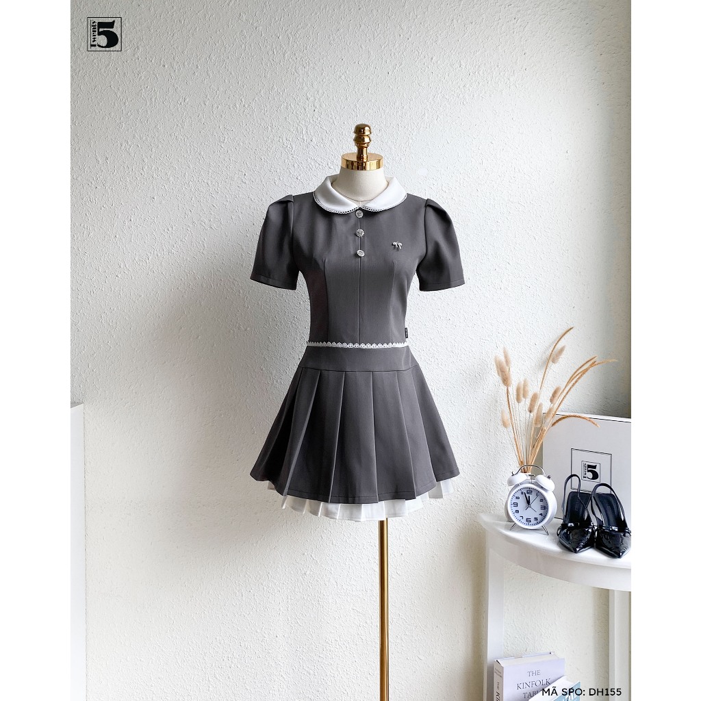 Đầm ngắn tay bồng Twentyfive , cổ bèo, đính cúc đá và nơ nhỏ ở ngực. Phối viền eo, xếp ly phần dưới 