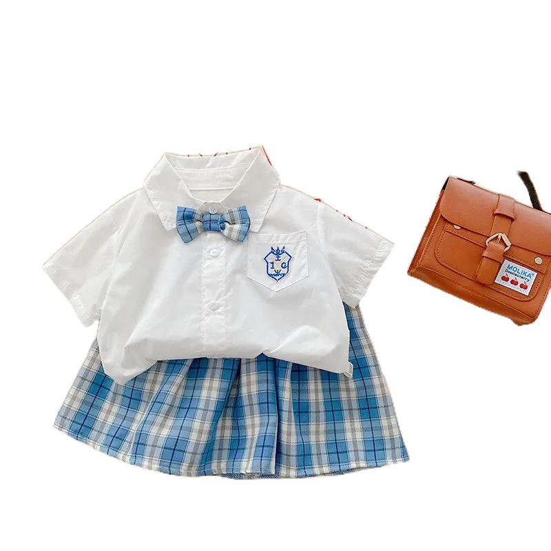 Sét Váy Áo Sơ Mi Nơ Cổ Túi Ngực In Logo Phối Chân Váy Thô Họa Tiết Caro Xếp Ly Phong Cách Hàn Quốc Cho Bé Gái 10-20 kg